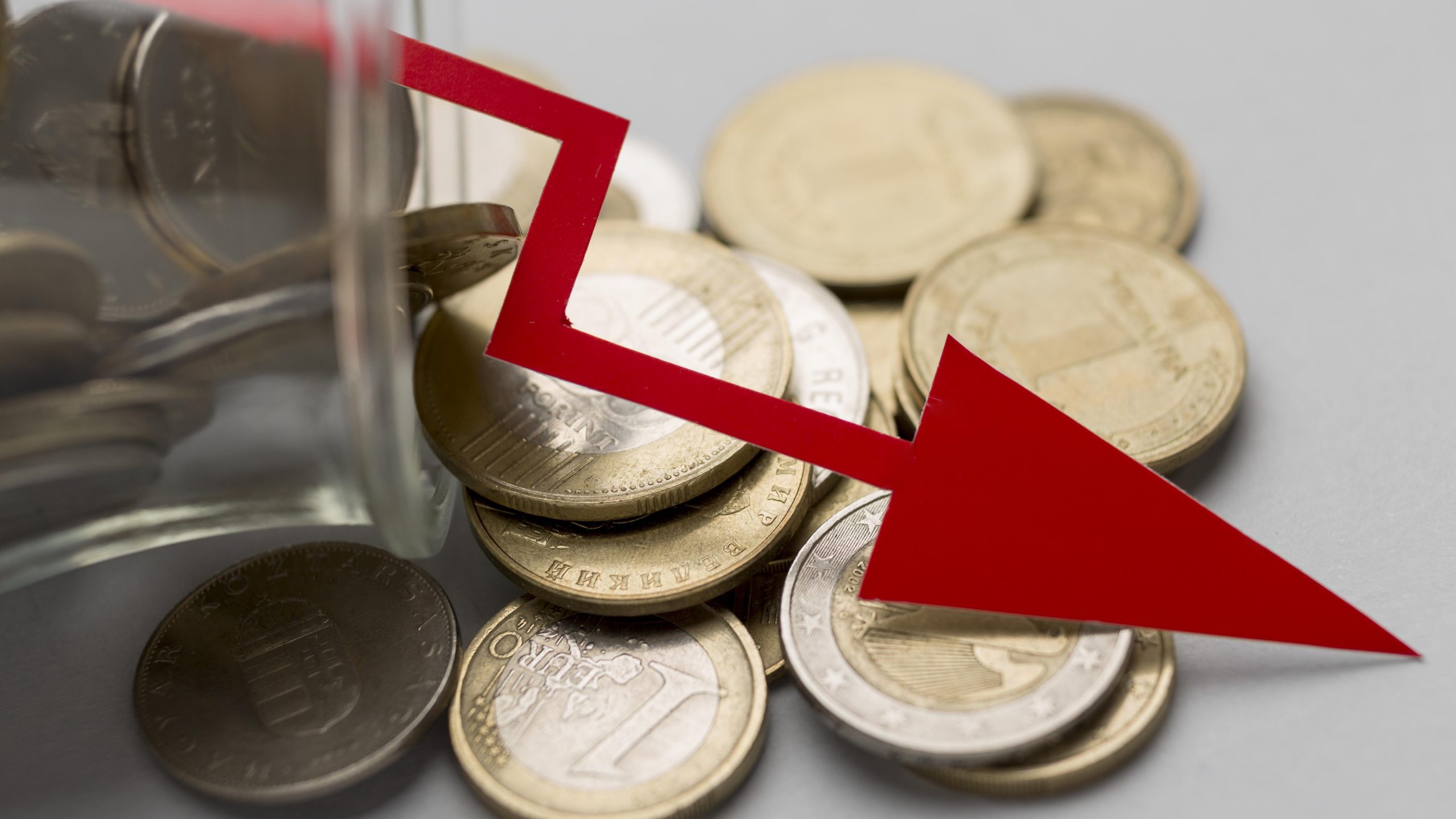 moedas e seta descendente representando queda
