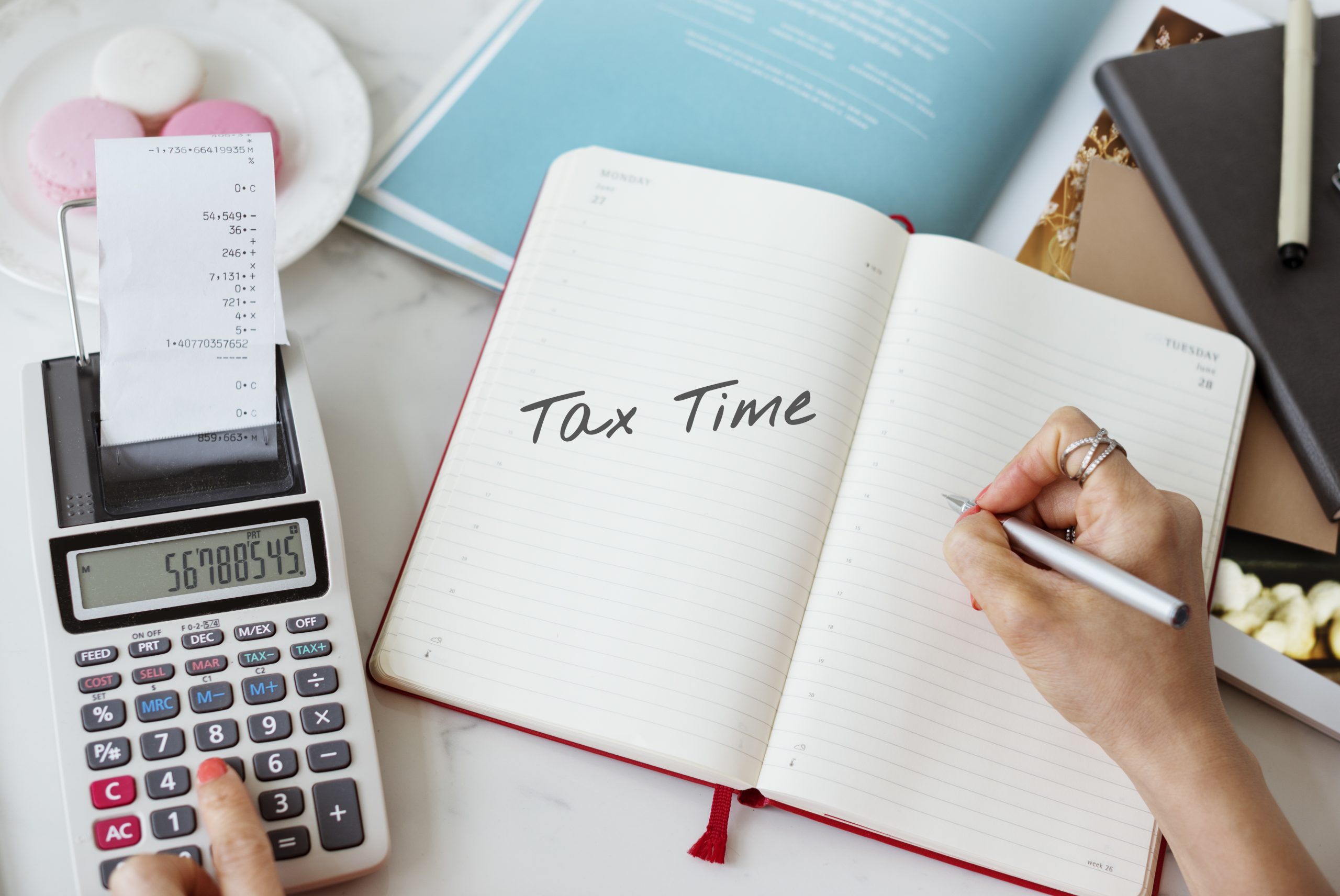 caderno escrito tax time representando cálculo de tributos