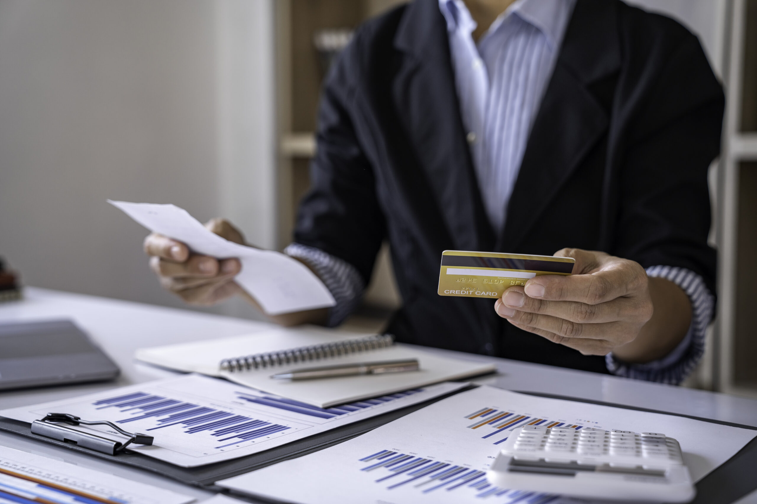 Close-up calculator  to calculate the company's financial results On the wooden table in the office and business work background, tax, accounting, statistics, and analytical research concept